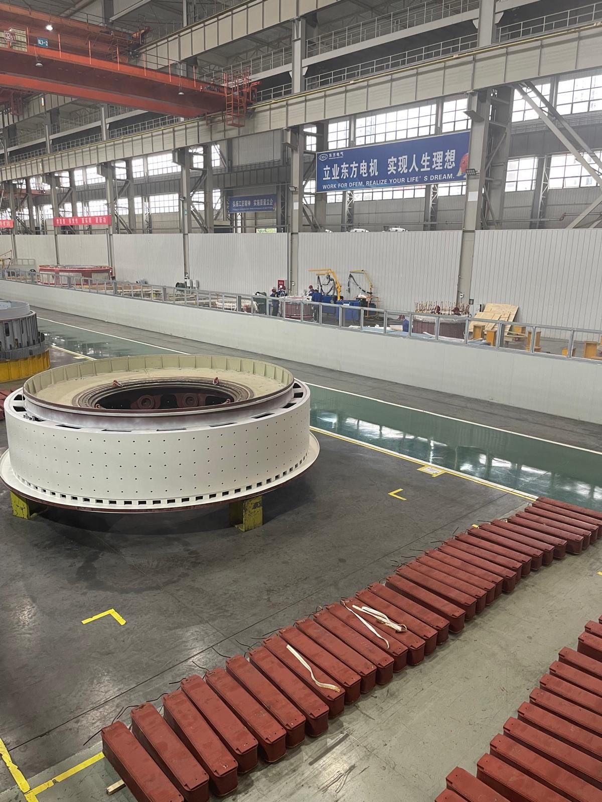 A large circular transformer core component on a factory floor